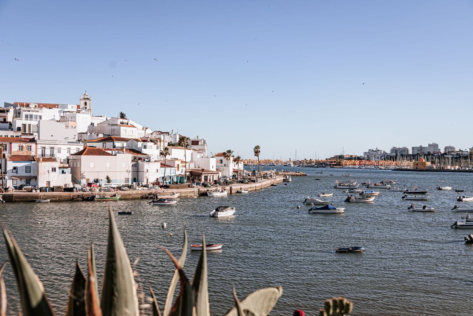 A vila de Ferragudo vista do rio Arade, com as casas brancas, a igreja e os barcos de pesca